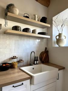 une cuisine avec évier blanc et étagères dans l'établissement Grange Aguila - Chalet au pied des pistes, à Vignec