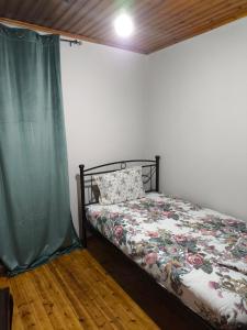 a bedroom with a bed with a green curtain at Το σπιτάκι in Mantamádos