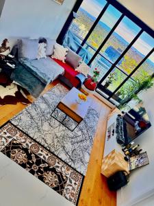 Una sala de estar con un sofá y una ventana grande. en Guest House- Light-Filled Apartment, en Box Hill