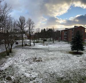 a park covered in snow in front of a building at Уютная квартира в 10 минутах от моря in Aseri +5 photos