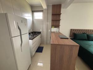 eine kleine Küche mit Kühlschrank und Couch in der Unterkunft Kitnet Suíte Premium in Bento Gonçalves