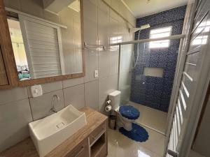 ein Badezimmer mit Waschbecken, Toilette und Spiegel in der Unterkunft Kitnet Suíte Premium in Bento Gonçalves