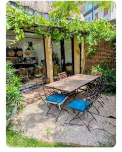 a wooden table and chairs sitting on a patio at Maison entre tour Eiffel et château de Versailles in Sèvres