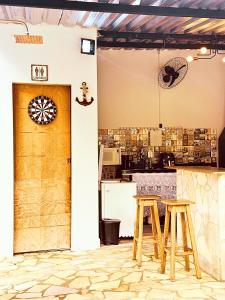 a kitchen with two wooden stools and a door at Ares da Bocaina Suítes in Bananal
