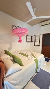 a bedroom with a bed with a pink umbrella on the wall at Goalma Family Holiday Resort & Restaurant in Anuradhapura
