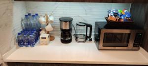 安曼Amazing Studio in DAMAC的厨房柜台配有微波炉和瓶装水。 更多27张照片