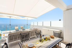 a balcony with a table and chairs with a view of the ocean at Breathtaking Bay views Nerja in Torrox