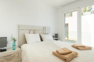 a bedroom with a white bed with two towels on it at Breathtaking Bay views Nerja in Torrox +34 photos