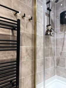 a shower with a glass door in a bathroom at New Modern 2 Bedroom Central Apt Greater Manchester, Sleeps 5, Near Airport with Great Transport Links in Stockport