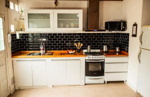 una cucina con mobili bianchi e un forno a piano cottura di Casa tipo Estudio de concepto abierto, Centrica, Parrilla, Cochera Privada y Portón Eléctrico a San Nicolás de los Arroyos