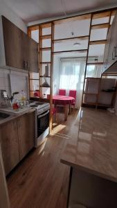 eine Küche mit Holzböden und eine Küche mit einem Tisch in der Unterkunft Stan Na Dan Ćuprija in Ćuprija