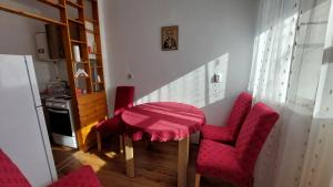 eine Küche mit einem Tisch und 2 roten Stühlen in der Unterkunft Stan Na Dan Ćuprija in Ćuprija