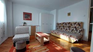 ein Wohnzimmer mit einer Couch und einem Sessel in der Unterkunft Stan Na Dan Ćuprija in Ćuprija