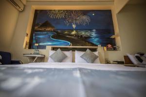 una camera da letto con un letto e un dipinto sul muro di Sabai B&B 澎湖船家寶民宿 a Huxi