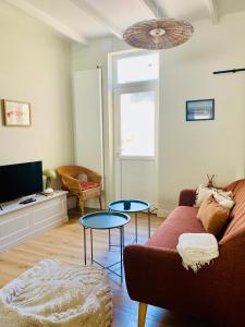 a living room with a couch and two tables at L Obione charmante maison de pêcheur rénovée proche mer avec patio extérieur in Le Tréport