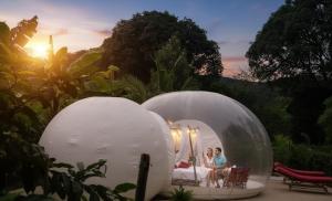 two people sitting in a bubble tent in a garden at Safari Bubbles in Wundanyi