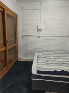 a white room with a bed with a window at Casa Térrea de praia confortável para famílias in Tramandaí