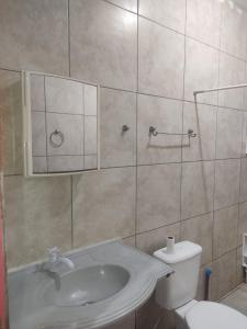 a bathroom with a sink and a toilet at Casa Térrea de praia confortável para famílias in Tramandaí