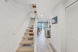 a staircase in a home with white walls and wooden floors at Napili Point C3 · NP C3 Renovated OceanFront to Whale Watch Rela in Kahana