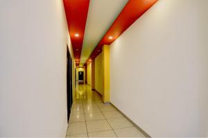 an empty hallway with red ceilings and white walls at Hotel O Elibrista in Meerut