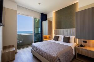 a bedroom with a bed and a large window at Hotel Palm Beach B&B SEA VIEW in Rimini +37 photos
