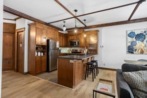 eine Küche mit Holzschränken und einer Arbeitsplatte in der Unterkunft Les Manoirs Wpool & Hot Tub Near Village 120-7 in Mont-Tremblant