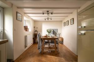 a kitchen and dining room with a table and chairs at 1 Rock Cottages in Treknow