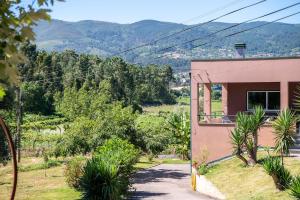 ein kleines Haus an einer Straße mit Bergen im Hintergrund in der Unterkunft Casa Carvalho de Bouça, Moreira Monção 
