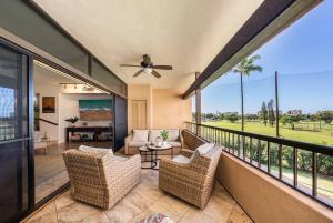 a screened in porch with two chairs and a table at Kaanapali Royal A303 · KRL A303 Relaxing Hawaiian 2BD on Golf Co in Lahaina