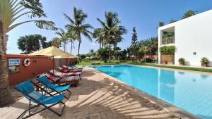 een groep ligstoelen naast een zwembad bij Leo's Beach Hotel - Adults Only in Brufut