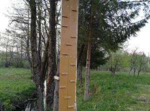 un poteau qui sort d'un arbre dans un champ dans l'établissement Lička Vodenica Rustical Oasis, à Modruš