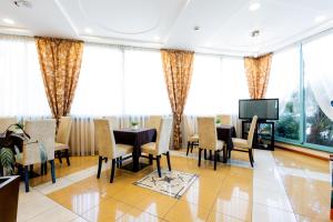 a dining room with tables and chairs and a tv at Hotel Palm Beach B&B SEA VIEW in Rimini