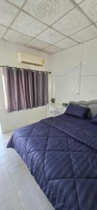 ein Schlafzimmer mit einer blauen Bettdecke auf einem Bett in der Unterkunft Khao Ban Eing in Ban Khlong Sai