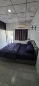 ein Schlafzimmer mit einem Bett mit einer blauen Bettdecke in der Unterkunft Khao Ban Eing in Ban Khlong Sai