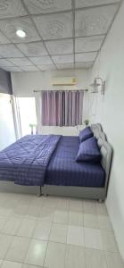 ein Schlafzimmer mit einem Bett mit violetter Bettwäsche und einem Fenster in der Unterkunft Khao Ban Eing in Ban Khlong Sai