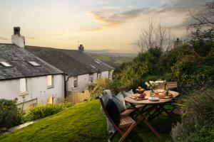 ein Tisch und Stühle auf einem Hof in der Unterkunft 1 Rock Cottages in Treknow