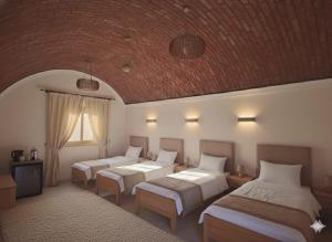 a bedroom with three beds and a brick ceiling at Crystala guest house in Aswan