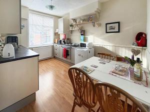 a kitchen with a table and chairs in a room at The Broomes in Whitstable