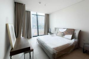 a bedroom with a bed and a large window at Luxurious 3 BR with Burj Khalifa View in Downtown in Dubai