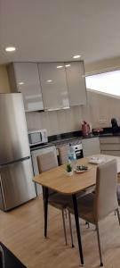 une cuisine avec une table en bois avec des chaises et un réfrigérateur dans l'établissement Beautiful View - Arco da Calheta - Ilha da Madeira, à Arco da Calheta