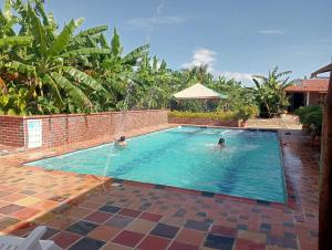 two people are swimming in a swimming pool at Curitagua Hotel Campestre in Curití