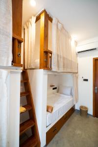 a bedroom with a bunk bed and a ladder at Riptide Surfhouse in Weligama