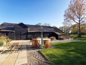 a house with a barbecue in the yard at The Stables - Uk50804 in Cratfield