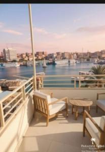 a balcony with a bench and a table and water at Crystala guest house in Aswan