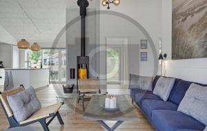 Una sala de estar con un sofá azul y una mesa. en 6 Bedroom Awesome Home In Glesborg, en Fjellerup Strand