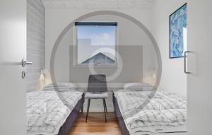 Un dormitorio con dos camas y una silla y un espejo. en 6 Bedroom Awesome Home In Glesborg, en Fjellerup Strand