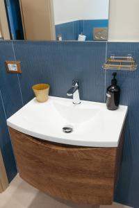 baño con lavabo blanco y pared azul en Frontemare Appartamenti e Camere ELISABETTA, en Cesenatico 63 fotos más
