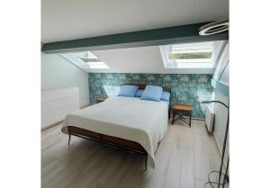 a bedroom with a bed with blue pillows at Chalet de 95m2 au cœur du Pays d'Auge, en Normandie avec Piscine et Jacuzzi in Les Champeaux +14 photos