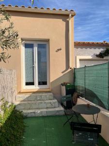ein Haus mit einer Terrasse mit einem Tisch und einem Fenster in der Unterkunft Le CLOS du LÉZARD - L'escapade in Port-la-Nouvelle