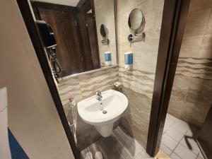 a bathroom with a sink and a mirror at فندق اصول الجوهرة بالعزيزية توصيل مجاني الى الحرم Asoul Al Jawhara Al Azizia Free Shuttle Service in Al ‘Azīzīyah